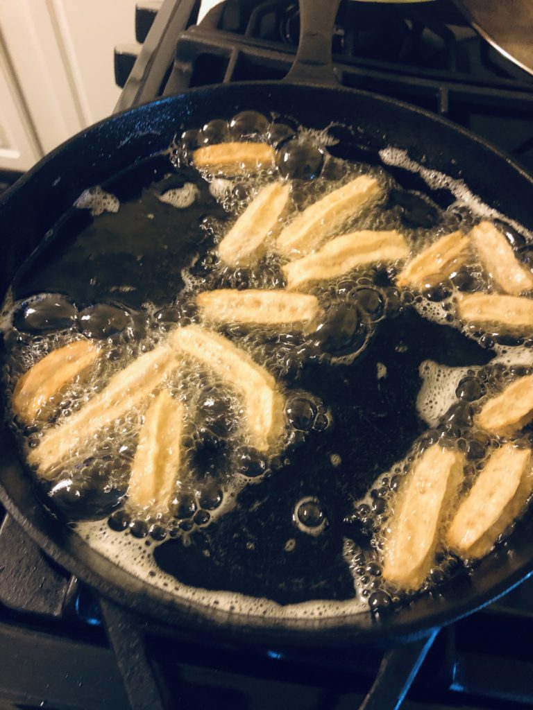 frying up my churro bites in my cast iron skillet until they are golden brown 