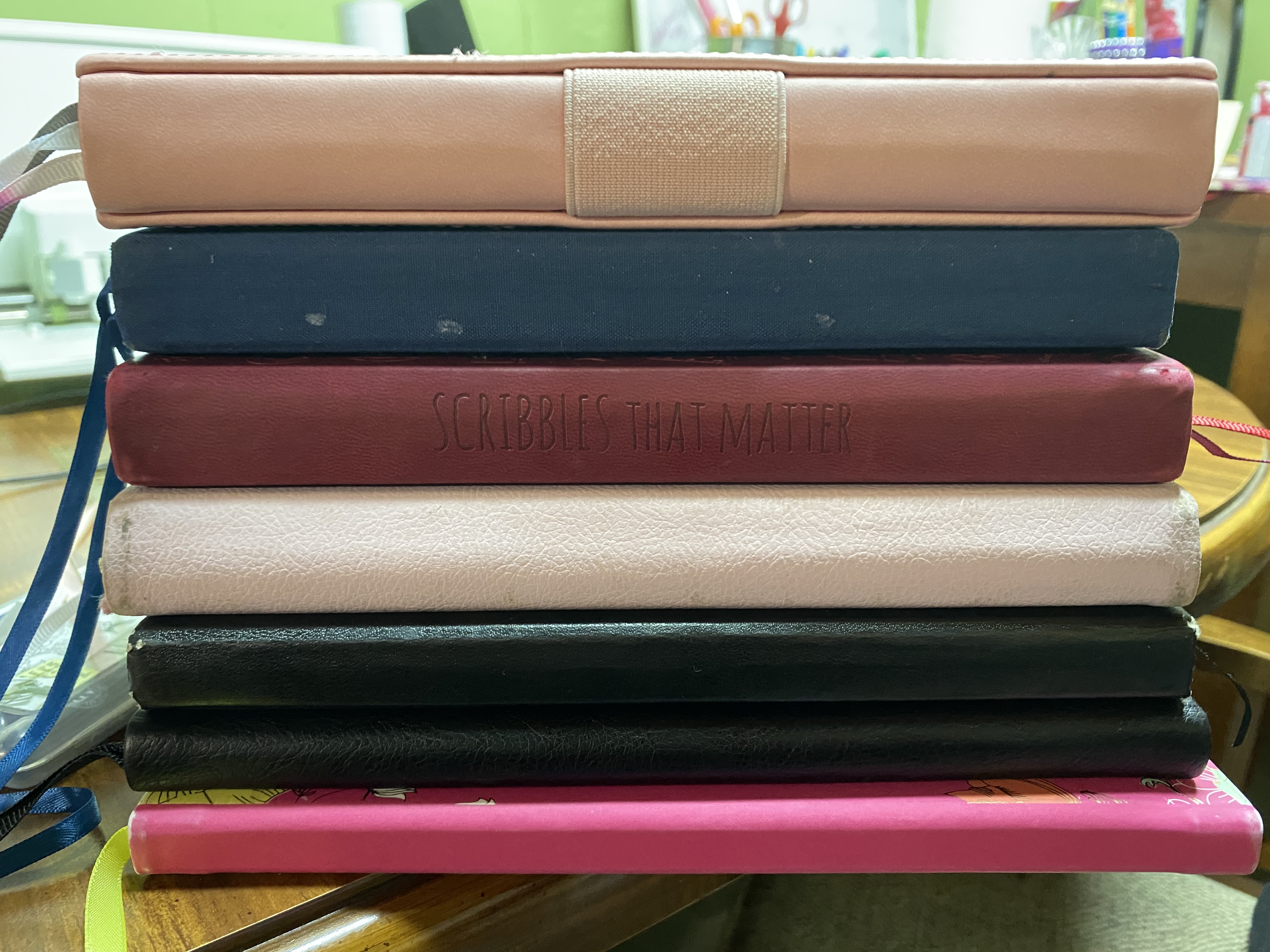 stack of bullet journal journals that i've used